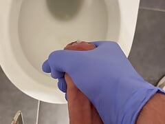 Jerking doctor at a toilet with latex gloves