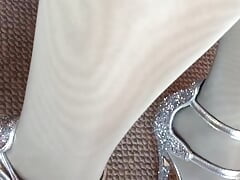 Leg tease in layerd shiny white crystal pantyhose and bright high heels.