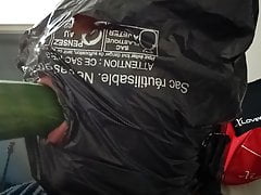 man sucking cucumber with head in garbage bag