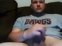 Stocky football player strokes fat cock