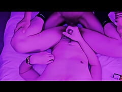 Two lustful guys fuck together in a room under romantic purple lights