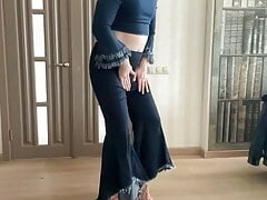 Crossdresser gay tranny in wide leg bootcut flare jeans and crop top and high heels dancing for his master and mistress