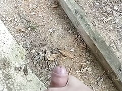 Cumming behind collapsed barn in the woods